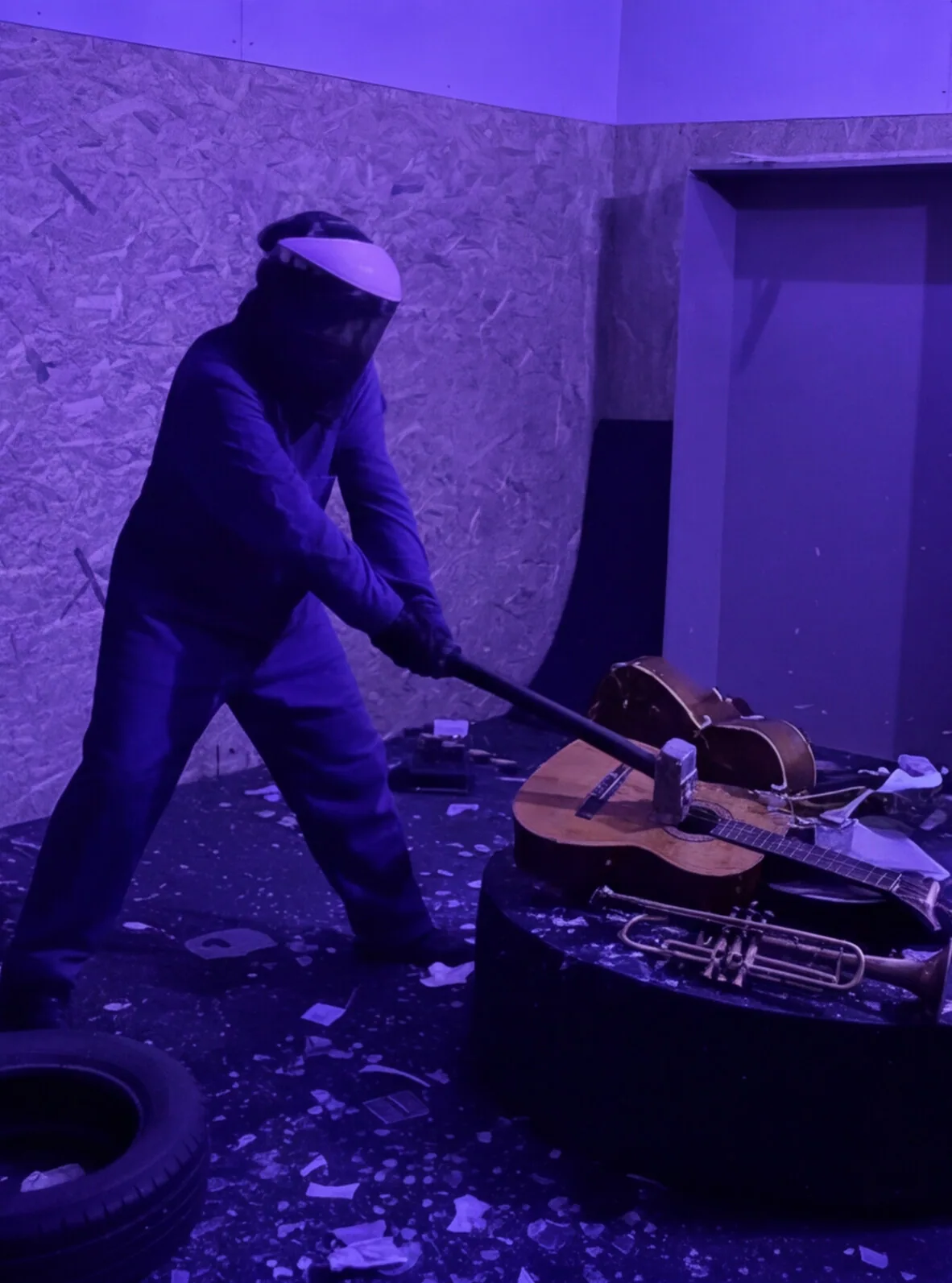 Persona destrozando una guitarra y una trompeta en la Rage Room de Break&Joy