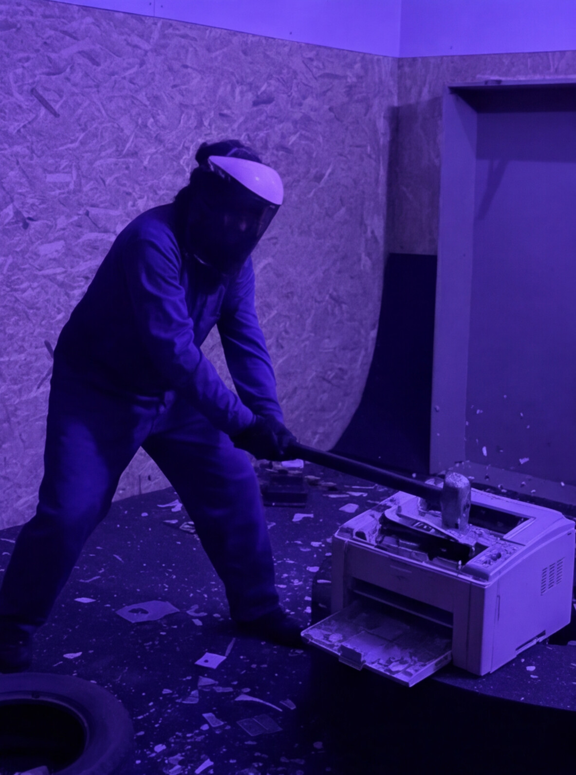Persona destrozando una impresora con una maza en la Rage Room de Break&Joy