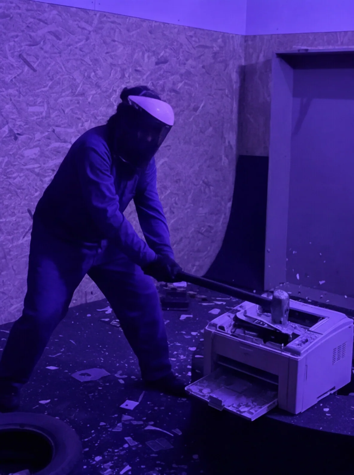 Persona destrozando una impresora con una maza en la Rage Room de Break&Joy