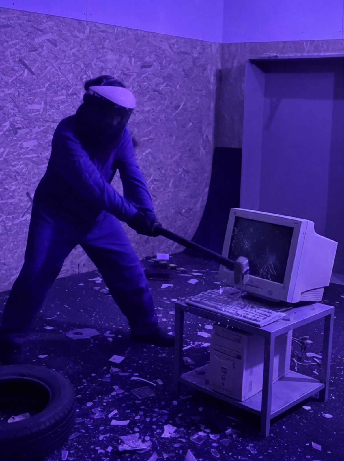 Persona destrozando un monitor CRT antiguo en la Rage Room de Break&Joy