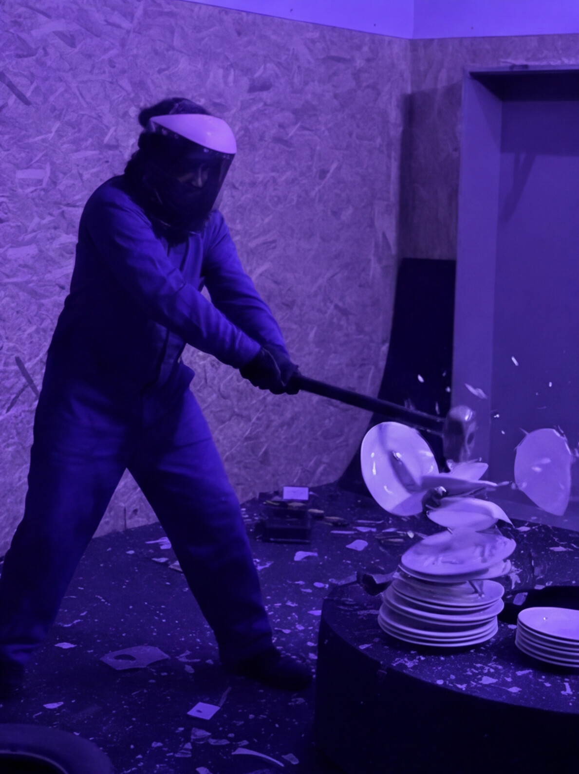 Persona rompiendo platos blancos con una maza en la Rage Room de Break&Joy Granada