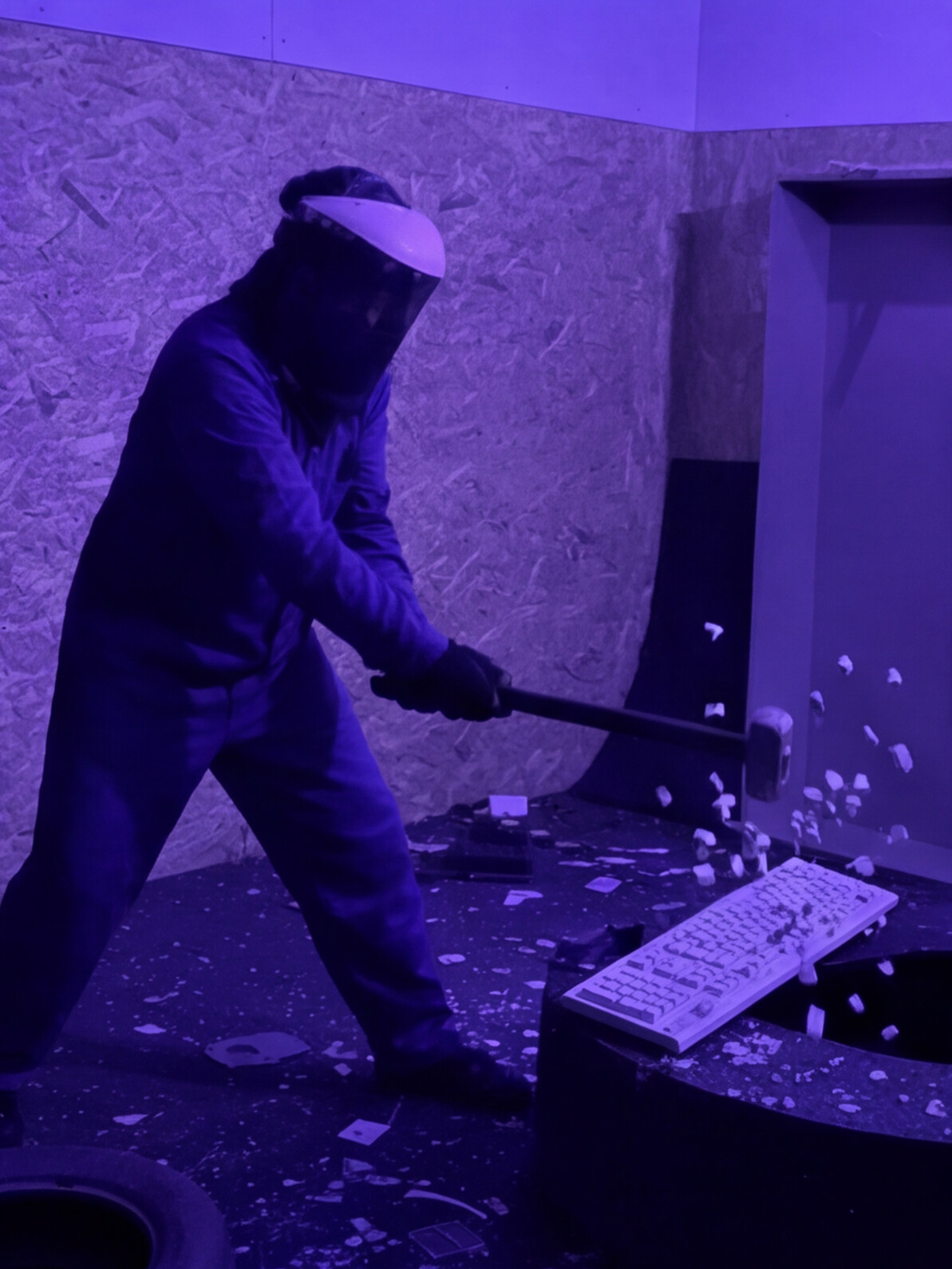 Persona destrozando un teclado con una maza en la Rage Room de Break&Joy
