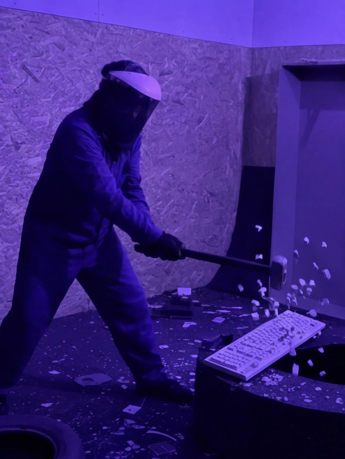 Persona destrozando un teclado con una maza en la Rage Room de Break&Joy