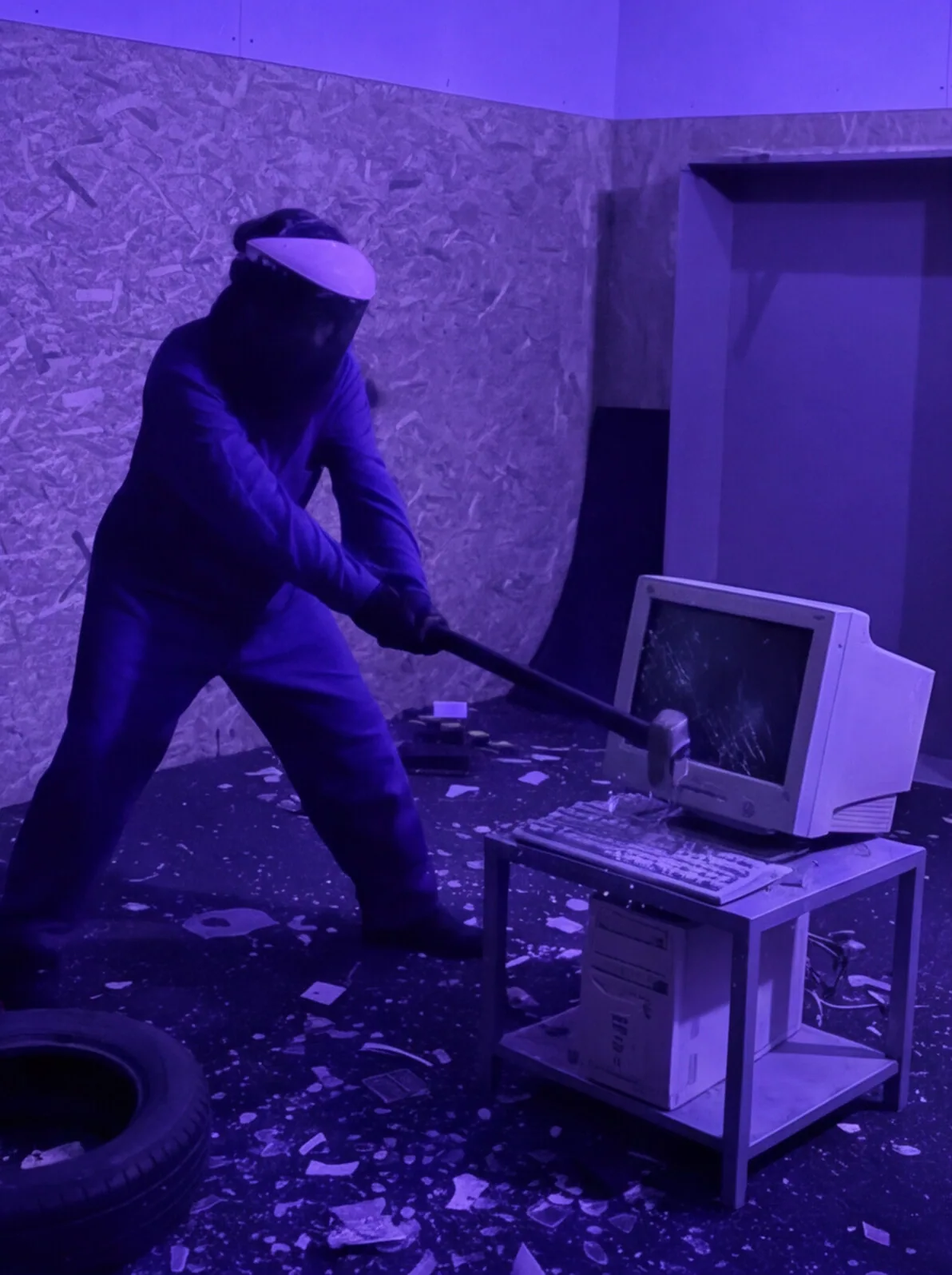 Persona destrozando un monitor CRT antiguo en la Rage Room de Break&Joy