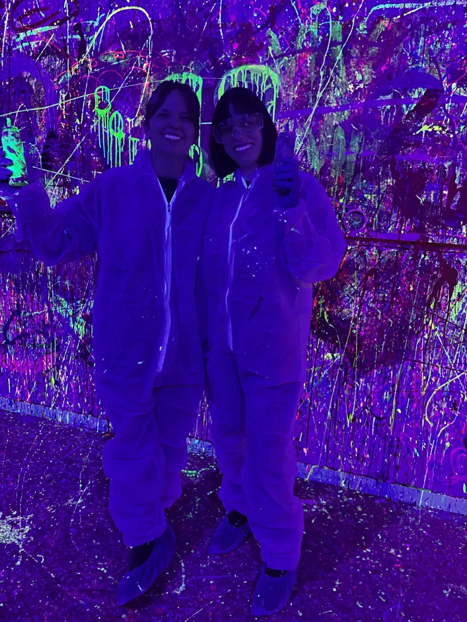 Clientes posando junto al mural de pintura fluorescente