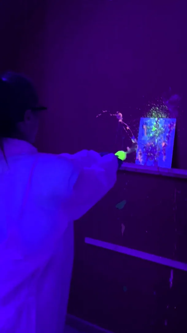 Pintura fluorescente neón bajo luz UV en la Splatter Room